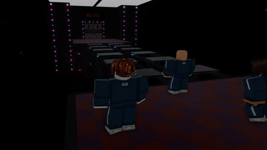 Image from 'Shrimp Game' in Roblox, a Squid Games inspired game, showing players in blue tracksuits positioned on a dark game floor lit by colorful lights, preparing to navigate through a challenging obstacle course as part of the game's strategic gameplay.